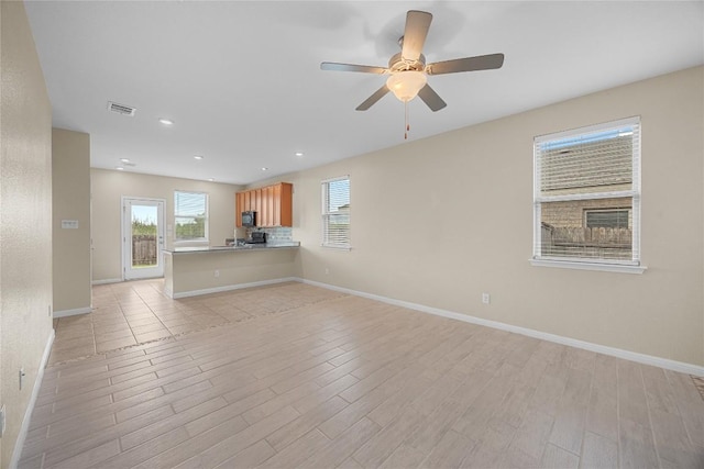 14125 Fallsprings Way, Manor, TX 78653 - unfurnished living room featuring light wood-style floors, a ceiling fan, and recessed lighting