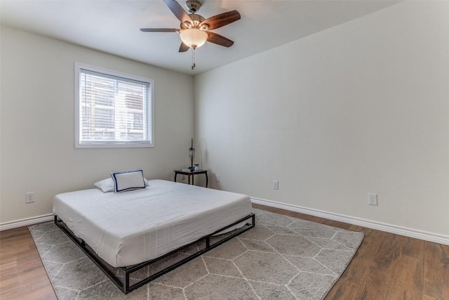 2401 Manor Rd Unit 113, Austin, TX 78722 - bedroom featuring wood finished floors, baseboards, and a ceiling fan