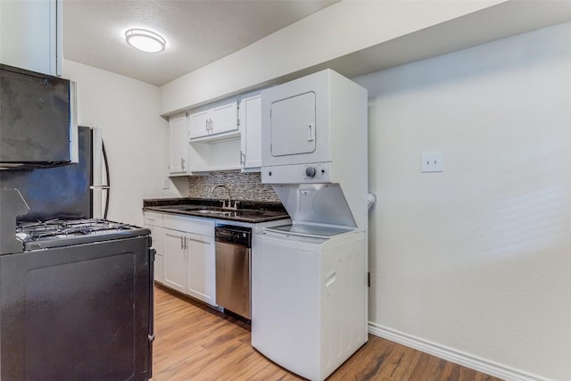 2401 Manor Rd Unit 113, Austin, TX 78722 - kitchen featuring stainless steel dishwasher, range with gas stovetop, stacked washing machine and dryer, light wood-style floors, and decorative backsplash