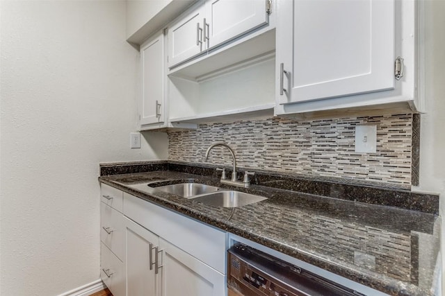 2401 Manor Rd Unit 113, Austin, TX 78722 - kitchen featuring a sink, backsplash, white cabinetry, dark stone countertops, and stainless steel dishwasher