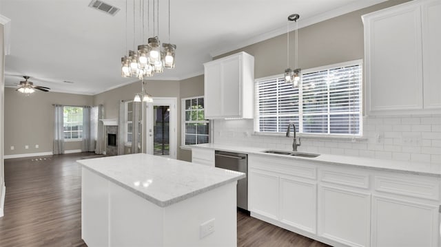 3504 Ashmere Loop SE, Round Rock, TX 78681 - kitchen with stainless steel dishwasher, decorative backsplash, a fireplace, a kitchen island, and dark wood finished floors