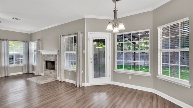 3504 Ashmere Loop SE, Round Rock, TX 78681 - unfurnished living room with a chandelier, wood finished floors, crown molding, and a tile fireplace