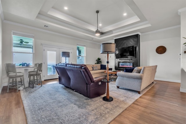 222 Overlook Trl, Copperas Cove, TX 76522 - living room with wood finished floors, a tray ceiling, baseboards, ornamental molding, and a fireplace
