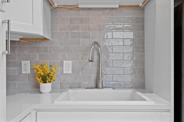1707 Collier St, Austin, TX 78704 - kitchen view of a sink, white cabinetry, tasteful backsplash, and light countertops