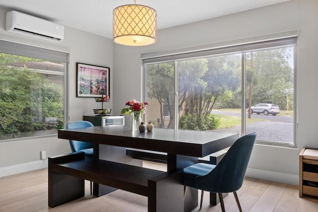 1707 Collier St, Austin, TX 78704 - dining area featuring an AC wall unit, baseboards, and light wood finished floors