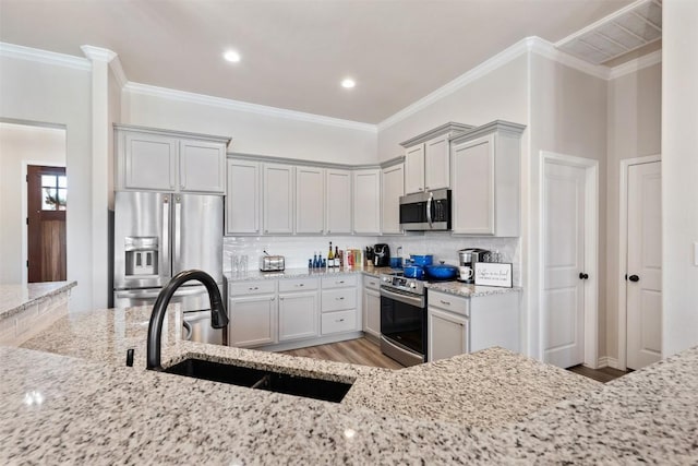 149 Metheglin Dr, Temple, TX 76502 - kitchen featuring stainless steel appliances, a sink, light wood-type flooring, light stone countertops, and backsplash