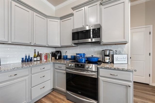 149 Metheglin Dr, Temple, TX 76502 - kitchen featuring stainless steel appliances, crown molding, backsplash, gray cabinets, and light wood finished floors