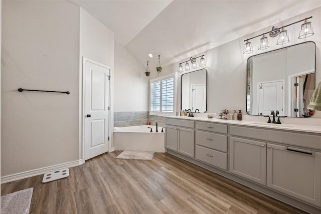 149 Metheglin Dr, Temple, TX 76502 - bathroom featuring a tub to relax in, lofted ceiling, double vanity, wood finished floors, and baseboards