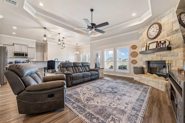 149 Metheglin Dr, Temple, TX 76502 - living area featuring a raised ceiling, ornamental molding, ceiling fan, a fireplace, and wood finished floors