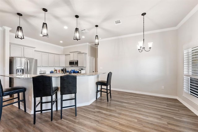 149 Metheglin Dr, Temple, TX 76502 - kitchen with appliances with stainless steel finishes, light wood-style flooring, crown molding, recessed lighting, and a breakfast bar area