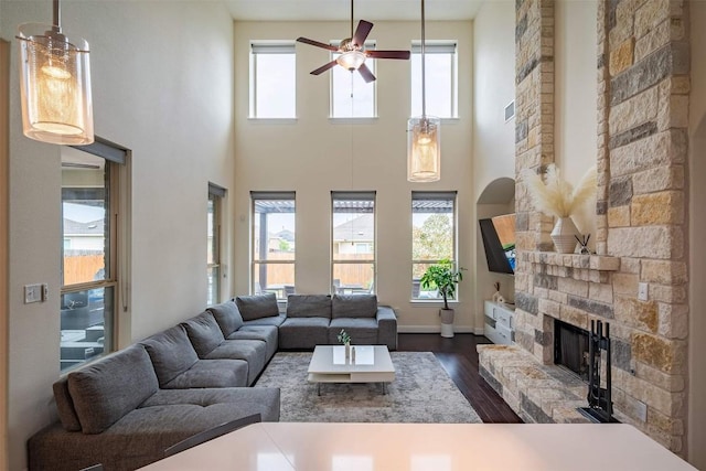 21305 Resource Rd, Pflugerville, TX 78660 - living room featuring ceiling fan, a fireplace, healthy amount of natural light, dark wood finished floors, and a towering ceiling