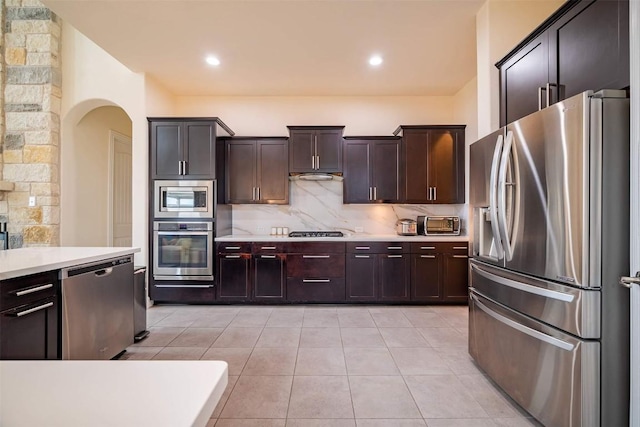 21305 Resource Rd, Pflugerville, TX 78660 - kitchen with appliances with stainless steel finishes, light countertops, arched walkways, and decorative backsplash