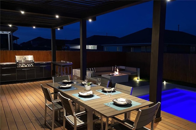 21305 Resource Rd, Pflugerville, TX 78660 - deck at night with a fenced backyard, an outdoor fire pit, and outdoor dining area