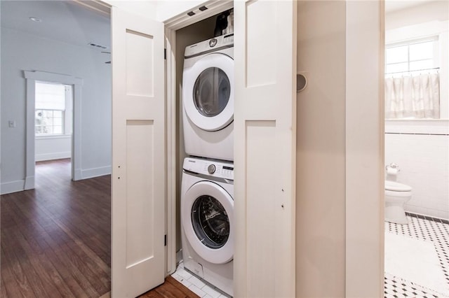 1206 W 22nd 1/2 St, Austin, TX 78705 - laundry room featuring stacked washing machine and dryer, dark wood-style floors, and baseboards