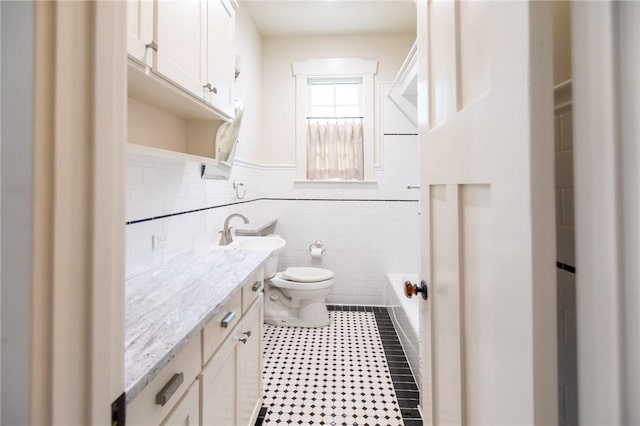 1206 W 22nd 1/2 St, Austin, TX 78705 - bathroom featuring toilet, vanity, a bath, and wainscoting