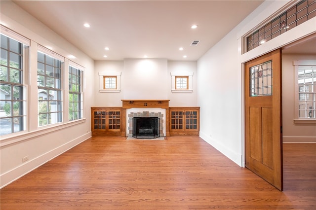 1206 W 22nd 1/2 St, Austin, TX 78705 - unfurnished living room with wood finished floors, baseboards, plenty of natural light, recessed lighting, and a tiled fireplace