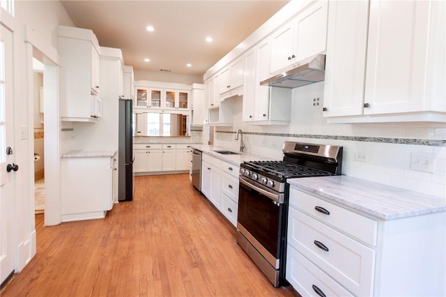 1206 W 22nd 1/2 St, Austin, TX 78705 - kitchen featuring stainless steel appliances, under cabinet range hood, a sink, white cabinets, and decorative backsplash