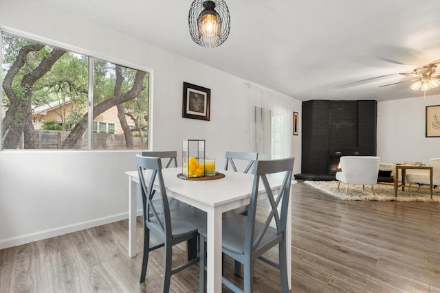 11533 Sandy Loam Trl, Austin, TX 78750 - dining room with a brick fireplace, wood finished floors, ceiling fan, and baseboards