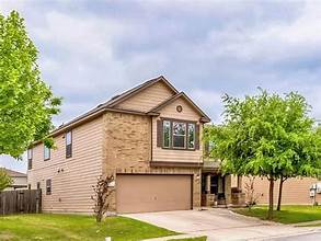 9008 Winter Haven Rd, Austin, TX 78747 - view of front of home with a garage, concrete driveway, and stone siding