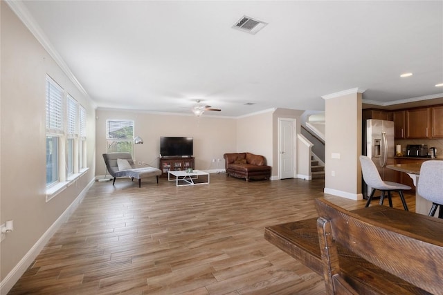 9008 Winter Haven Rd, Austin, TX 78747 - living area featuring ceiling fan, stairs, baseboards, ornamental molding, and light wood-type flooring