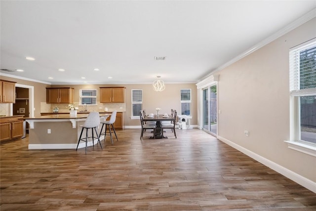9008 Winter Haven Rd, Austin, TX 78747 - kitchen with backsplash, crown molding, a breakfast bar area, plenty of natural light, and recessed lighting