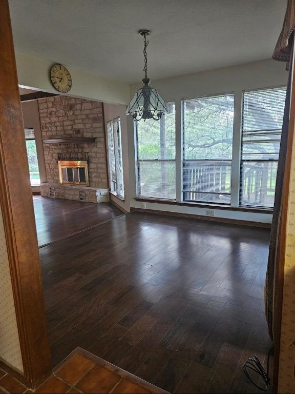 319 Fawnridge St, Georgetown, TX 78628 - unfurnished living room featuring a chandelier, dark wood-style floors, and a fireplace