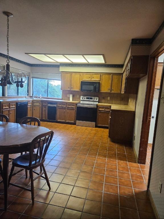 319 Fawnridge St, Georgetown, TX 78628 - kitchen with black appliances, light countertops, tile patterned flooring, a chandelier, and tasteful backsplash