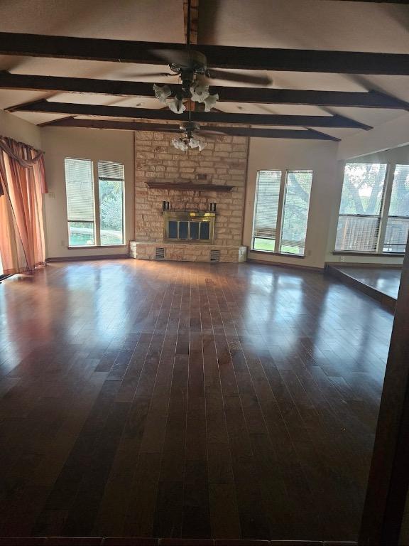319 Fawnridge St, Georgetown, TX 78628 - unfurnished living room featuring beamed ceiling, ceiling fan, dark wood-type flooring, and a fireplace
