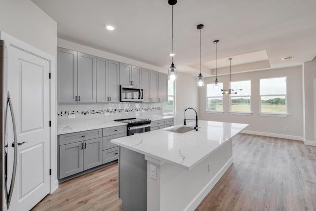 203 Alonzo Dr, Del Valle, TX 78617 - kitchen with stainless steel microwave, gray cabinets, electric stove, light wood-style flooring, and recessed lighting