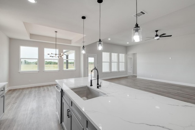 203 Alonzo Dr, Del Valle, TX 78617 - kitchen featuring light wood finished floors, decorative light fixtures, dishwasher, light stone counters, and recessed lighting