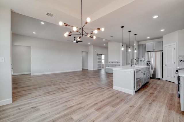203 Alonzo Dr, Del Valle, TX 78617 - kitchen with appliances with stainless steel finishes, gray cabinets, light countertops, open floor plan, and a chandelier