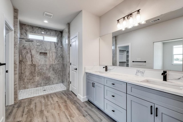 203 Alonzo Dr, Del Valle, TX 78617 - bathroom with a marble finish shower, double vanity, healthy amount of natural light, and wood finished floors