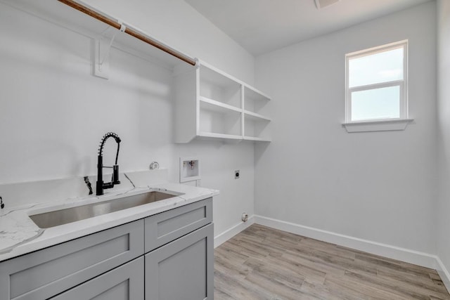 203 Alonzo Dr, Del Valle, TX 78617 - laundry area featuring electric dryer hookup, cabinet space, light wood-style floors, and washer hookup