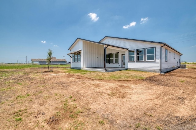 203 Alonzo Dr, Del Valle, TX 78617 - rear view of property with a patio and board and batten siding