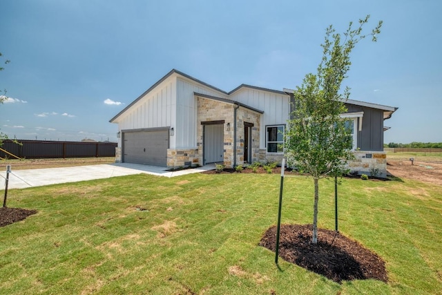 203 Alonzo Dr, Del Valle, TX 78617 - view of front facade with board and batten siding, driveway, a garage, and stone siding