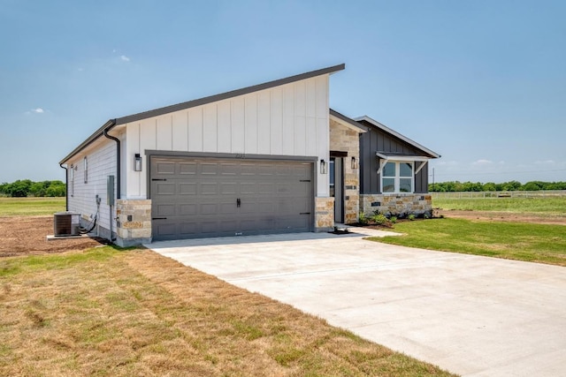 203 Alonzo Dr, Del Valle, TX 78617 - view of front of home with stone siding, a garage, driveway, a front yard, and board and batten siding