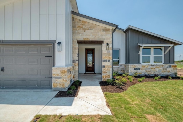 203 Alonzo Dr, Del Valle, TX 78617 - entrance to property featuring board and batten siding, stone siding, a yard, and an attached garage