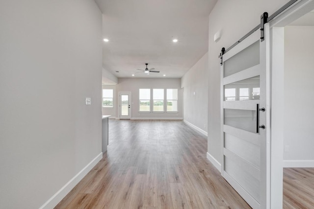 203 Alonzo Dr, Del Valle, TX 78617 - unfurnished living room with a barn door, light wood-style floors, recessed lighting, and ceiling fan