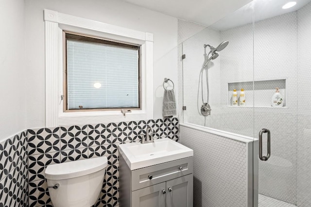 810 River Rd, Wimberley, TX 78676 - bathroom featuring vanity, tile walls, a shower stall, toilet, and a wainscoted wall
