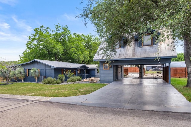 810 River Rd, Wimberley, TX 78676 - view of front facade with metal roof, driveway, a carport, and stairway