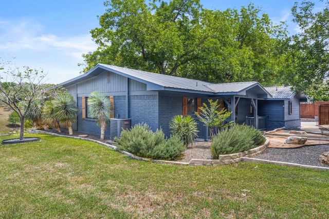 810 River Rd, Wimberley, TX 78676 - view of front of house with metal roof, brick siding, and central air condition unit