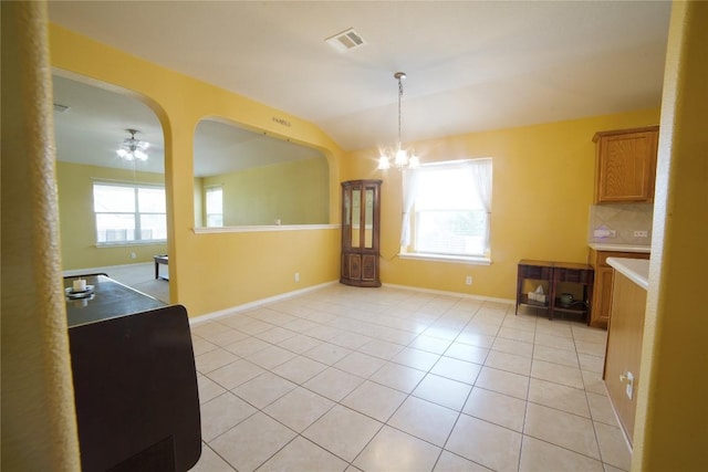 1800 Quiet Meadows Cv, Pflugerville, TX 78660 - unfurnished dining area featuring a chandelier, healthy amount of natural light, light tile patterned flooring, arched walkways, and vaulted ceiling