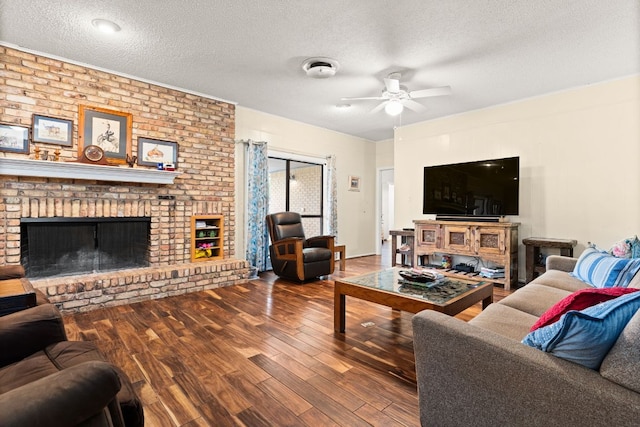 112 Skipcha Trl, Lampasas, TX 76550 - living room featuring ceiling fan, wood finished floors, a textured ceiling, and a brick fireplace