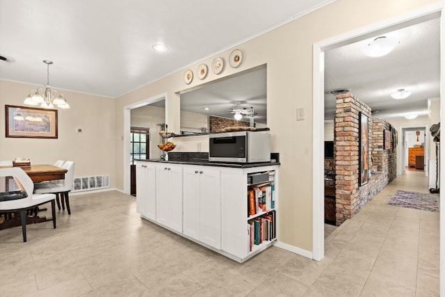 112 Skipcha Trl, Lampasas, TX 76550 - kitchen featuring dark countertops, white cabinets, baseboards, a chandelier, and crown molding