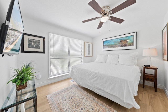 403 Horseshoe Bay Blvd N, Horseshoe Bay, TX 78657 - bedroom with baseboards, light wood-type flooring, and ceiling fan