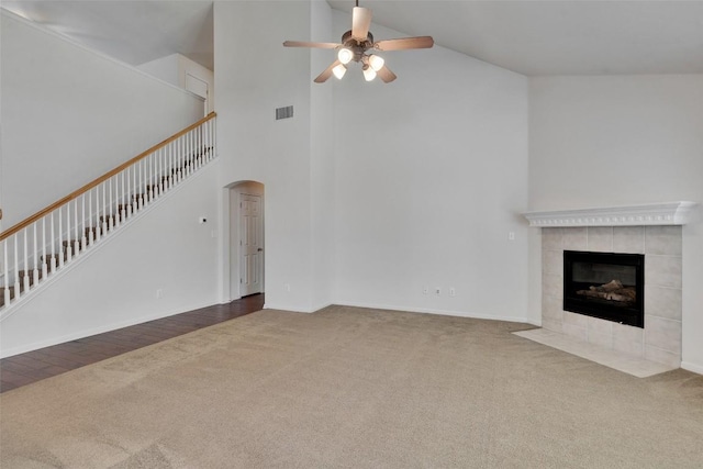 2225 Lou John St, Austin, TX 78727 - unfurnished living room featuring carpet floors, ceiling fan, arched walkways, high vaulted ceiling, and a tiled fireplace