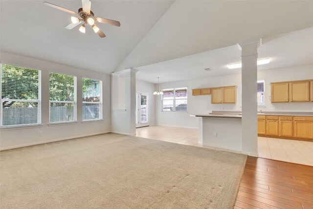 2225 Lou John St, Austin, TX 78727 - unfurnished living room featuring a ceiling fan, decorative columns, high vaulted ceiling, and light wood-style floors