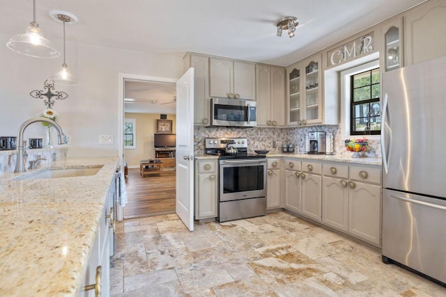 25404 Hamilton Pool Rd, Round Mountain, TX 78663 - kitchen with appliances with stainless steel finishes, a sink, backsplash, glass insert cabinets, and hanging light fixtures