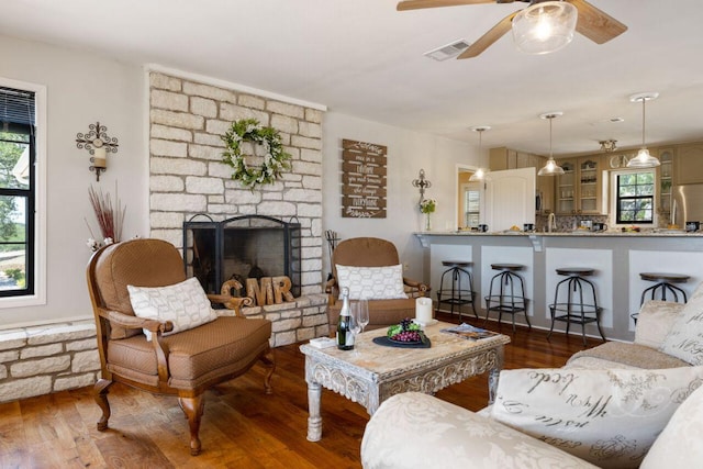 25404 Hamilton Pool Rd, Round Mountain, TX 78663 - living room with ceiling fan, wood finished floors, plenty of natural light, and a stone fireplace