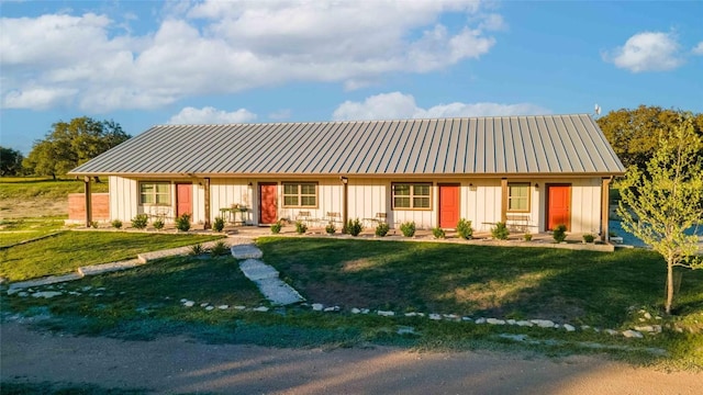 25404 Hamilton Pool Rd, Round Mountain, TX 78663 - view of front facade featuring board and batten siding, metal roof, and a front yard